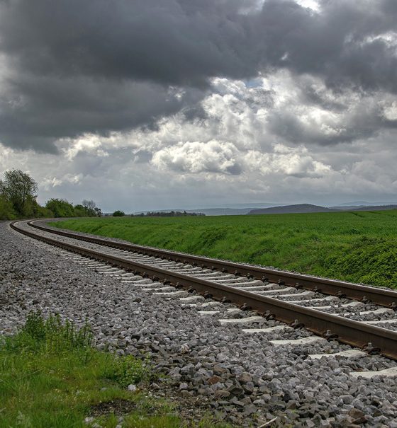 Eisenbahngleise unter einem grauen bewölkten Himme
