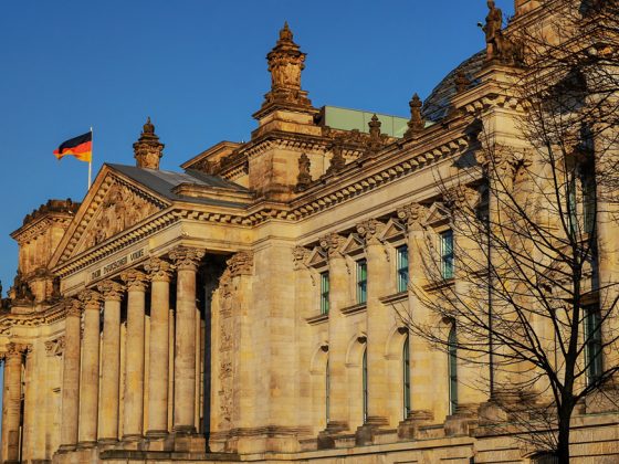 Das Reichstagsgebäude in Berlin mit einer kleinen schwarzrotgoldenen Flagge