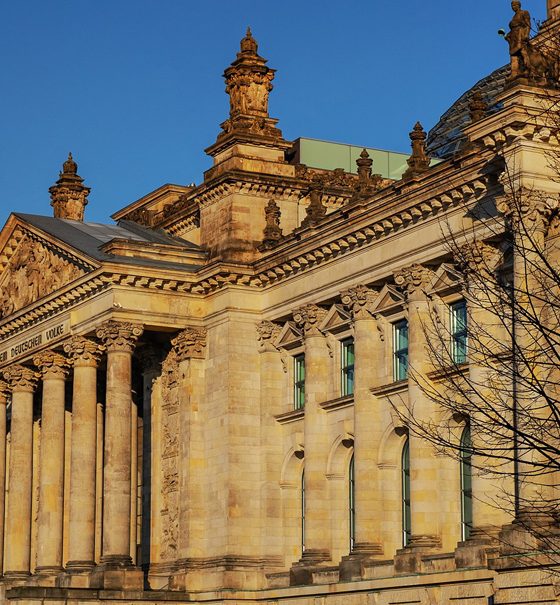 Das Reichstagsgebäude in Berlin mit einer kleinen schwarzrotgoldenen Flagge
